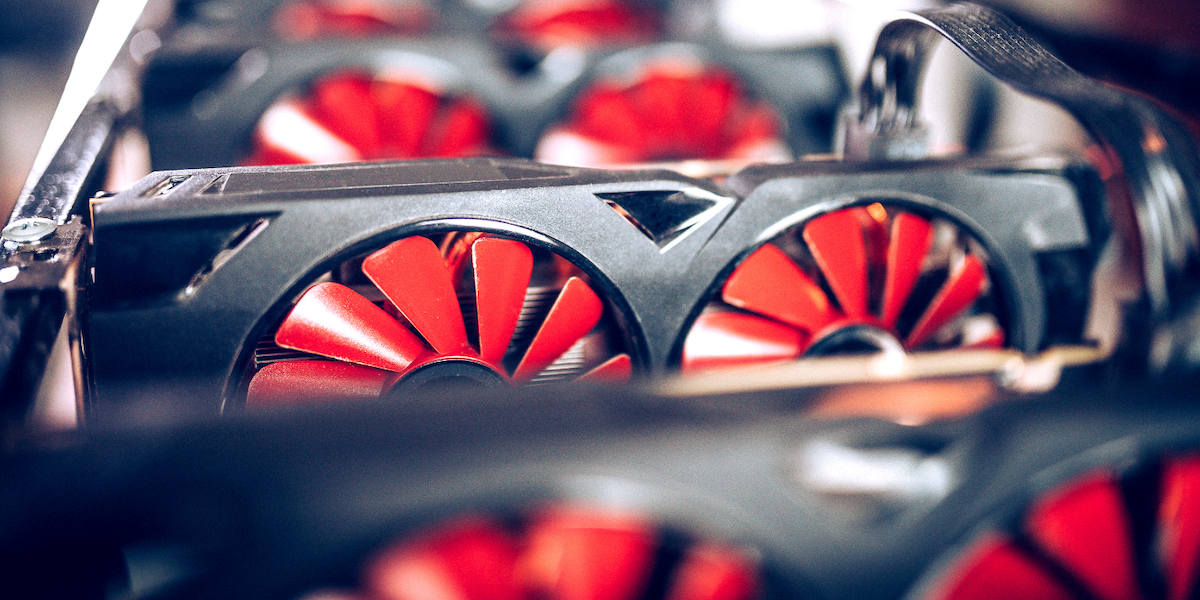 Multiple GPU cards with distinctive red-bladed fans lined up, highlighting their cooling mechanisms