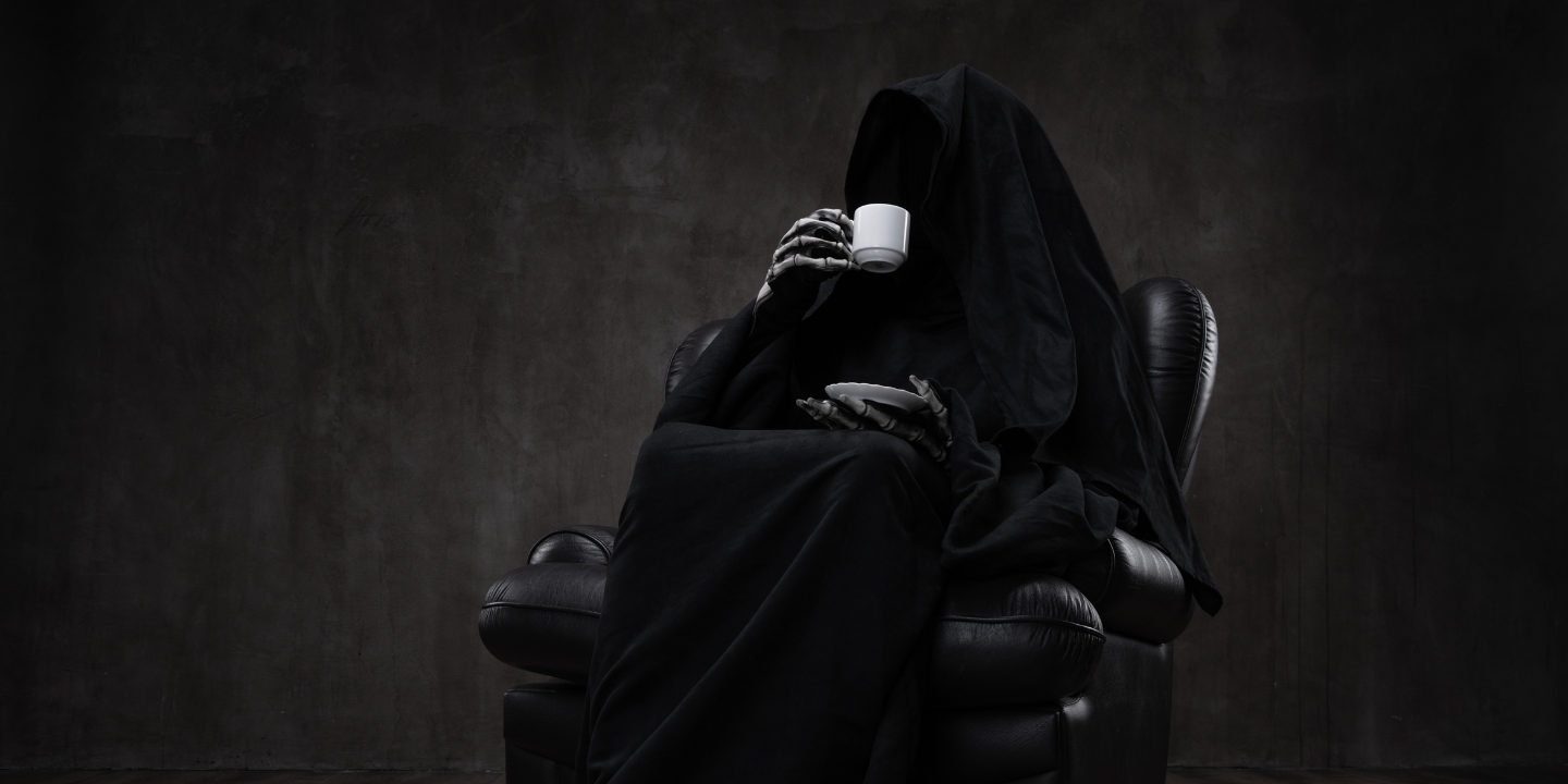 Mysterious figure in a black robe sitting on a leather chair, holding a white cup, with a plain dark background
