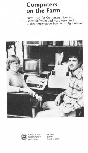 Black and white photo of two individuals at a desk with a farm computer, with text about agricultural computer use